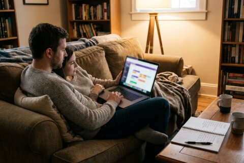 Verlobtes Paar sucht am Laptop gemeinsam nach Hochzeitsdienstleistern